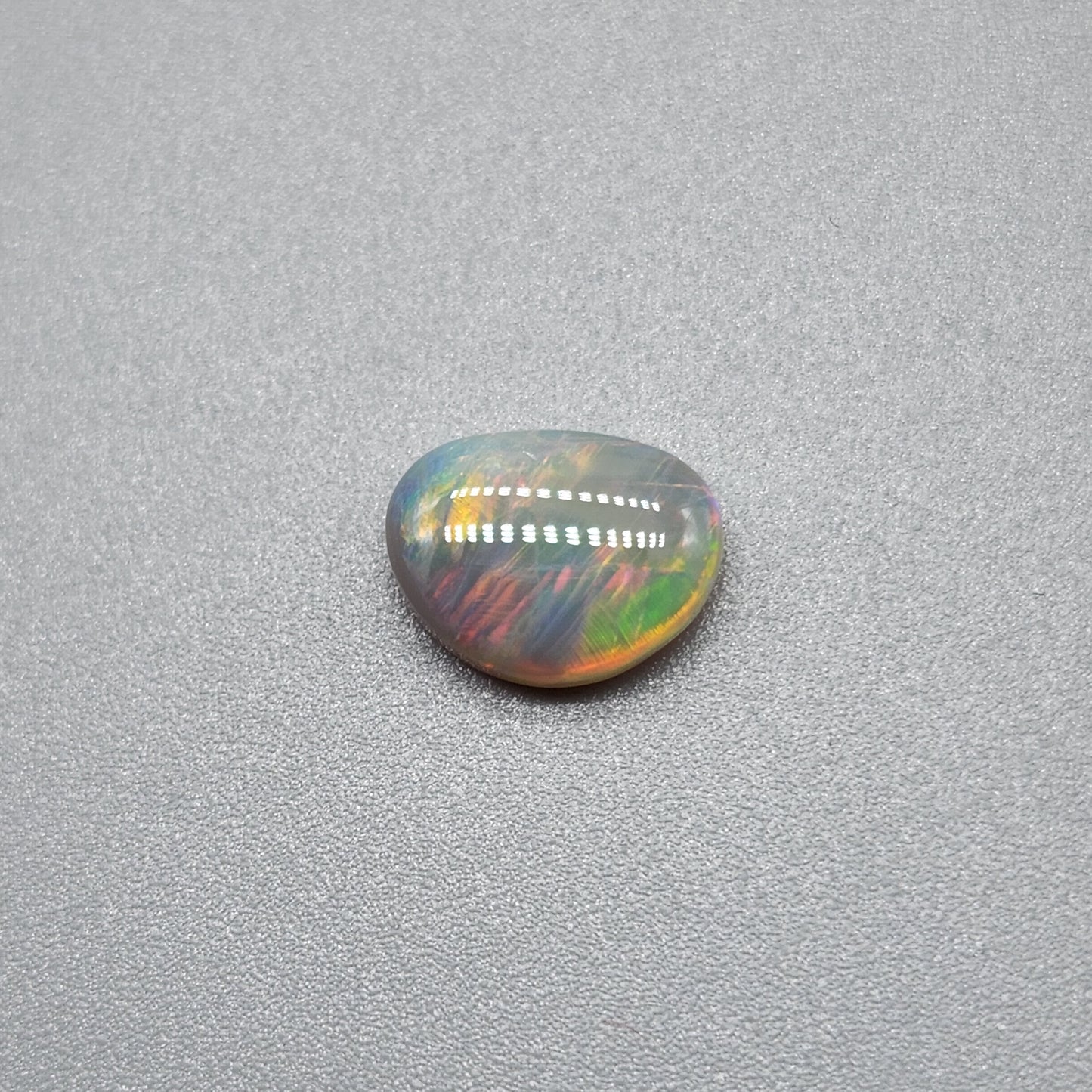 1cts Dark opal with a fiery color pallet and a feathery broad flash pattern