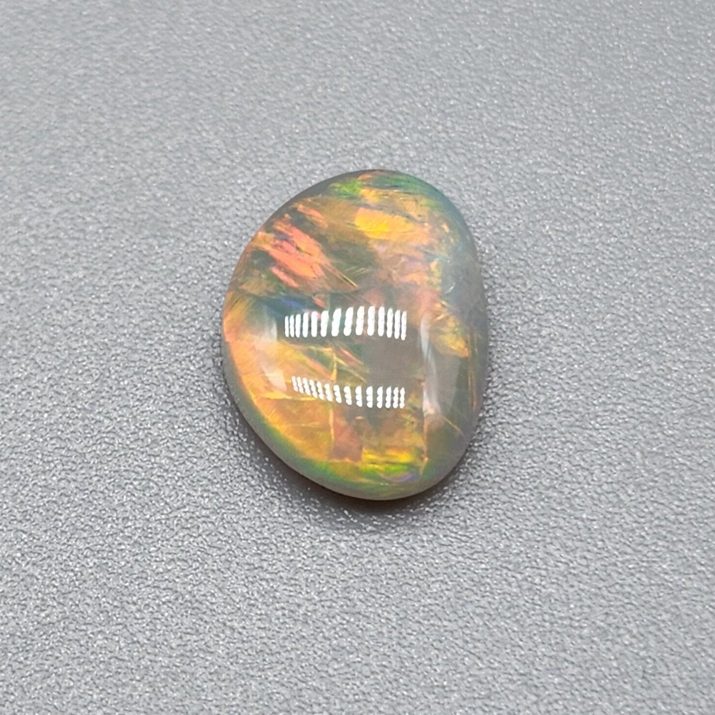 1cts Dark opal with a fiery color pallet and a feathery broad flash pattern