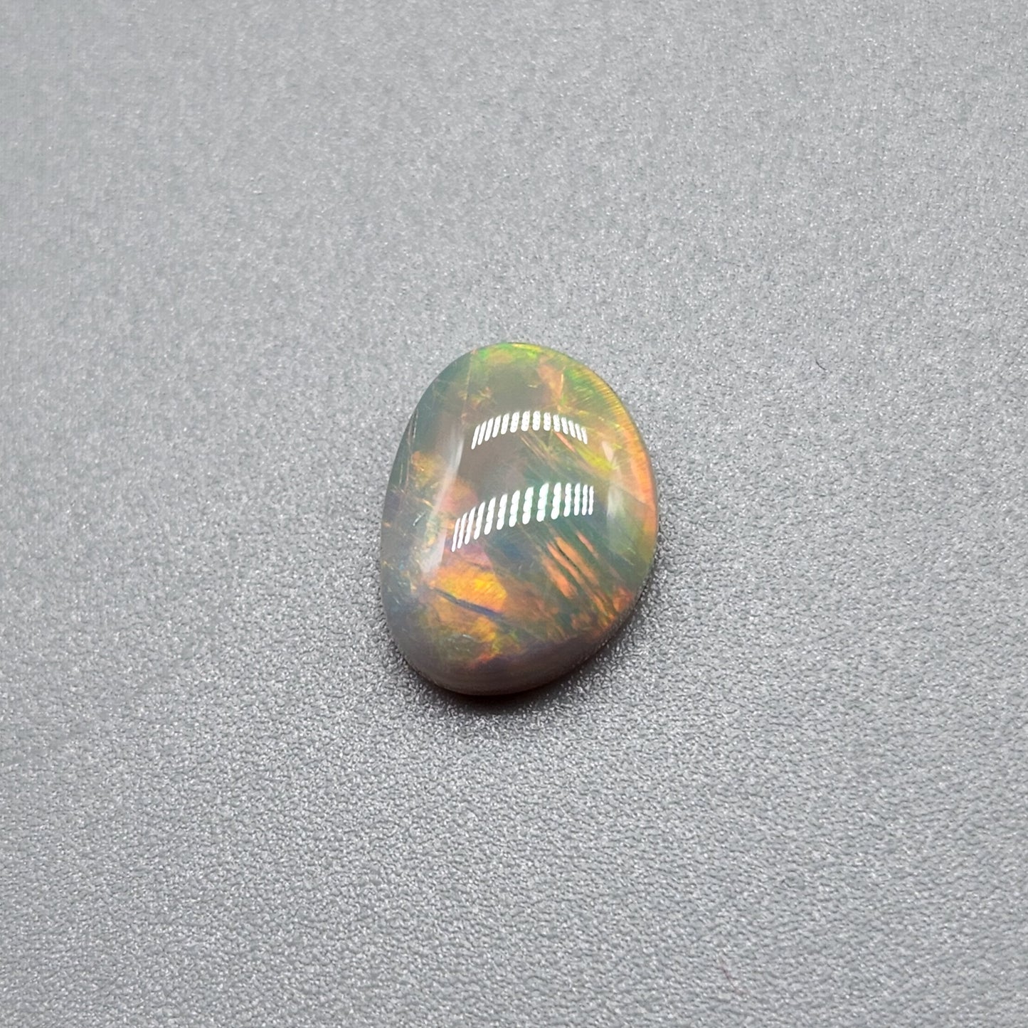 1cts Dark opal with a fiery color pallet and a feathery broad flash pattern