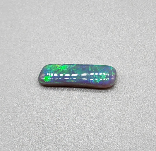 1.3cts Dark opal with elongated freeform shape and blue and green color play