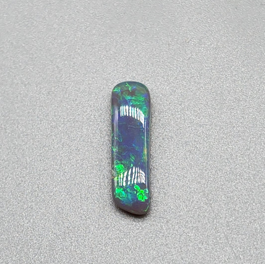 1.3cts Dark opal with elongated freeform shape and blue and green color play