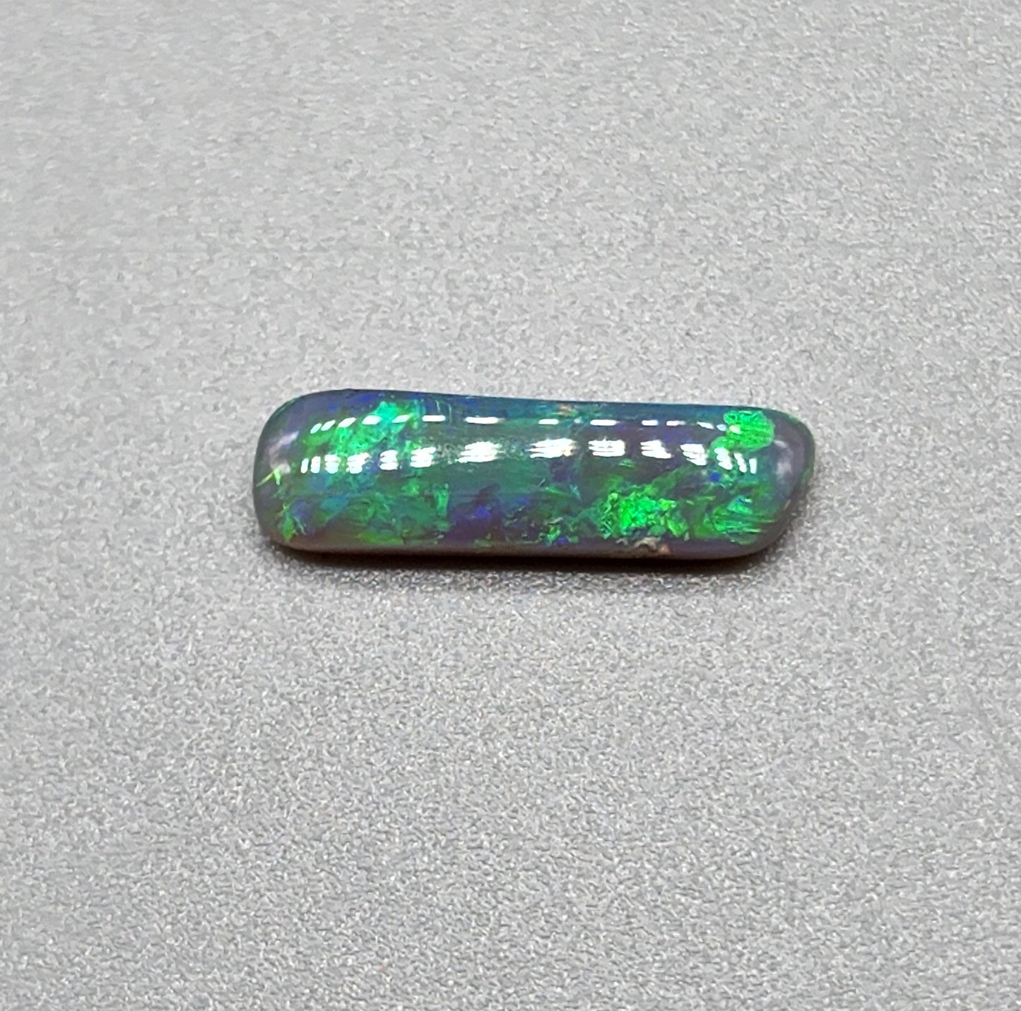 1.3cts Dark opal with elongated freeform shape and blue and green color play