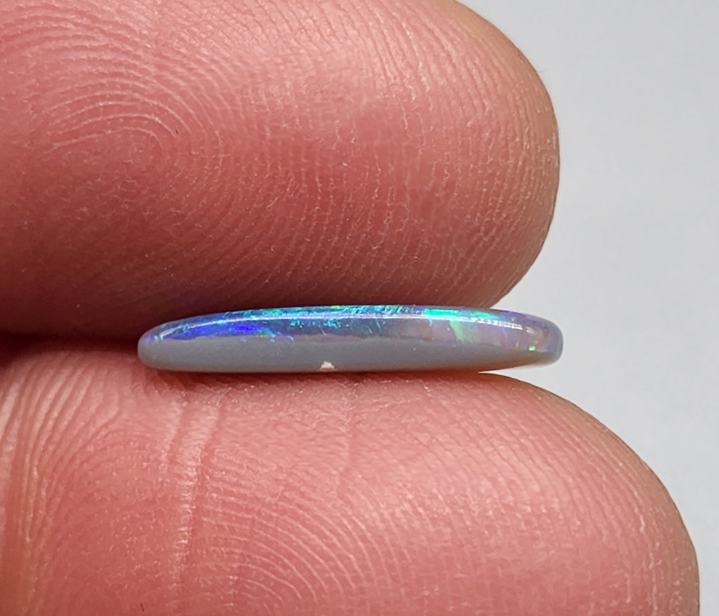 1.3cts Dark opal with elongated freeform shape and blue and green color play