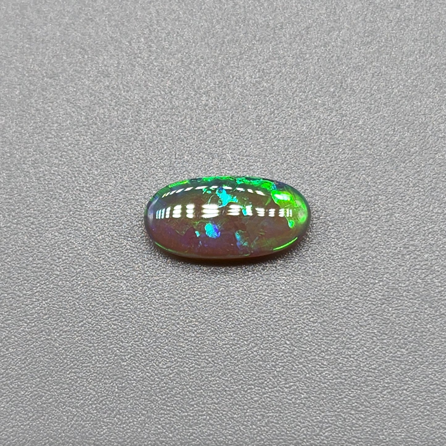 0.5ct Dark Opal with vivid green flash and hints of blue