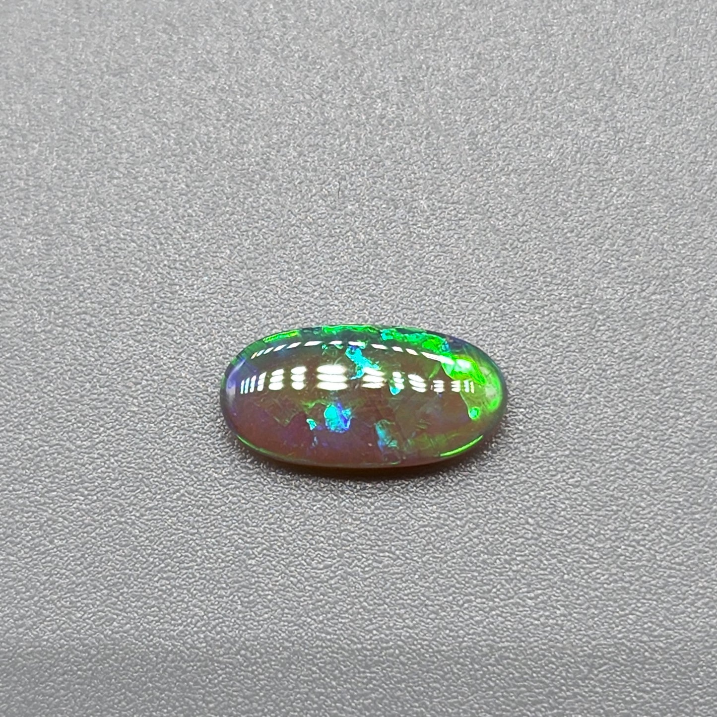 0.5ct Dark Opal with vivid green flash and hints of blue