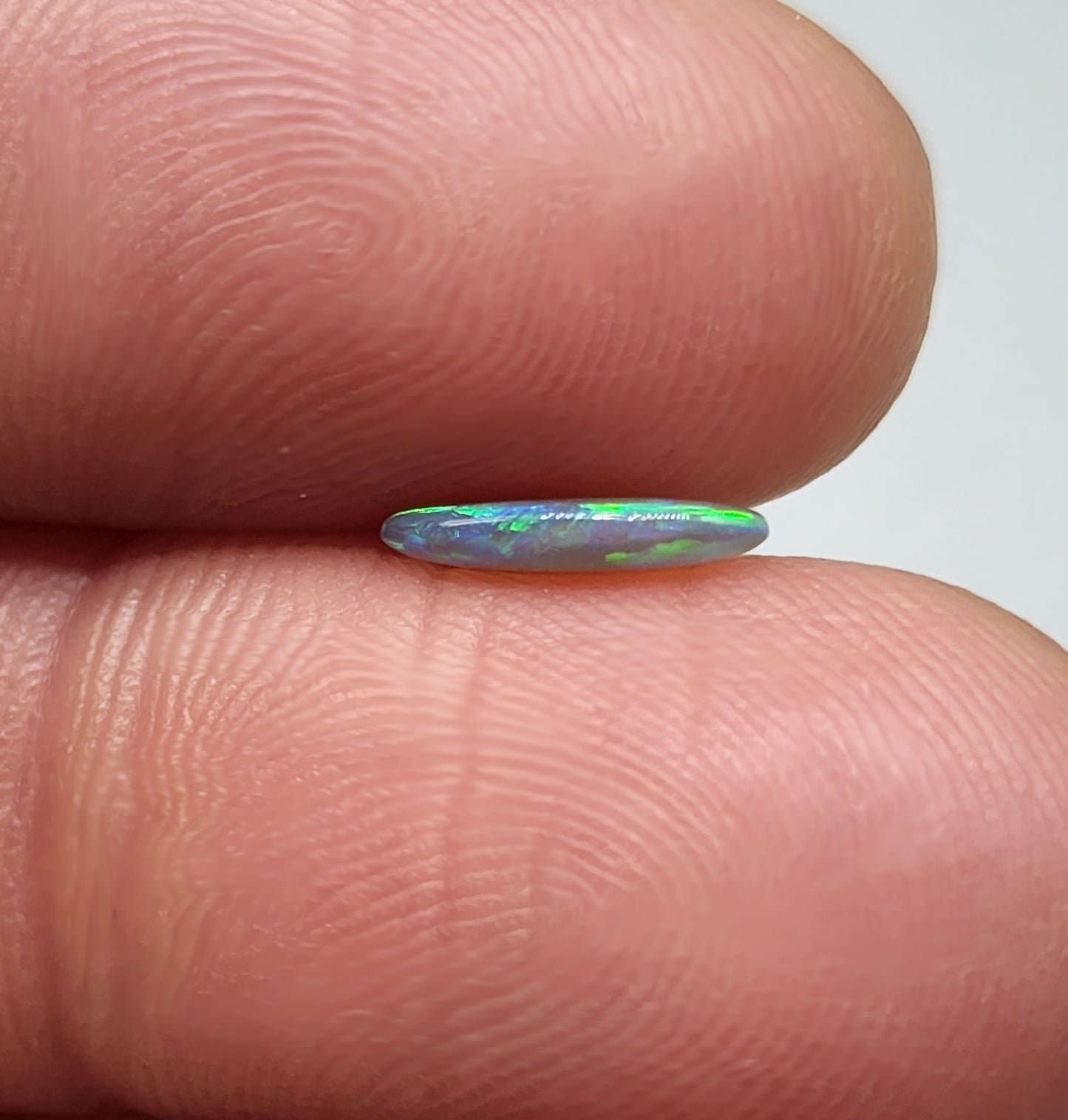 0.5ct Dark Opal with vivid green flash and hints of blue