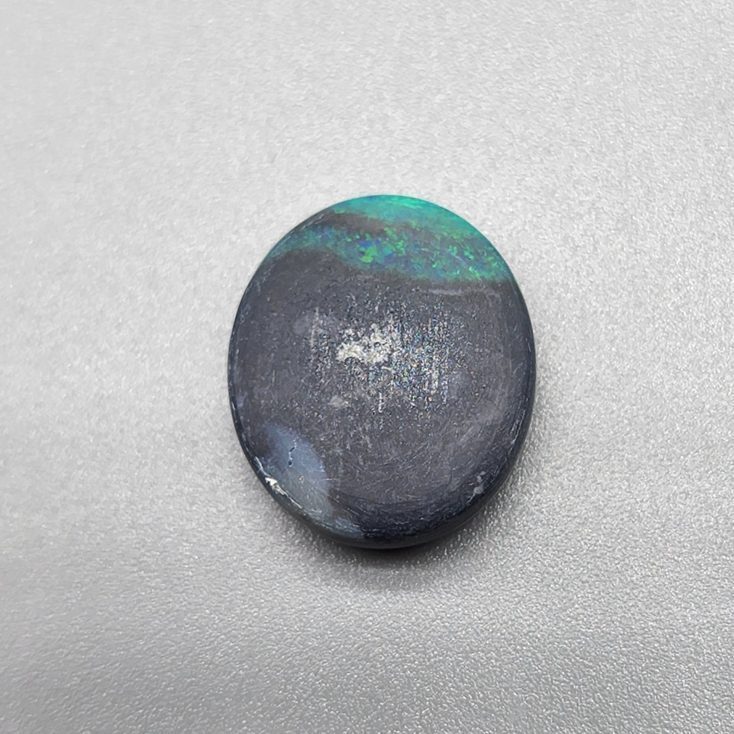 5cts Black Opal with a blue/green color pallet and galaxy pattern.