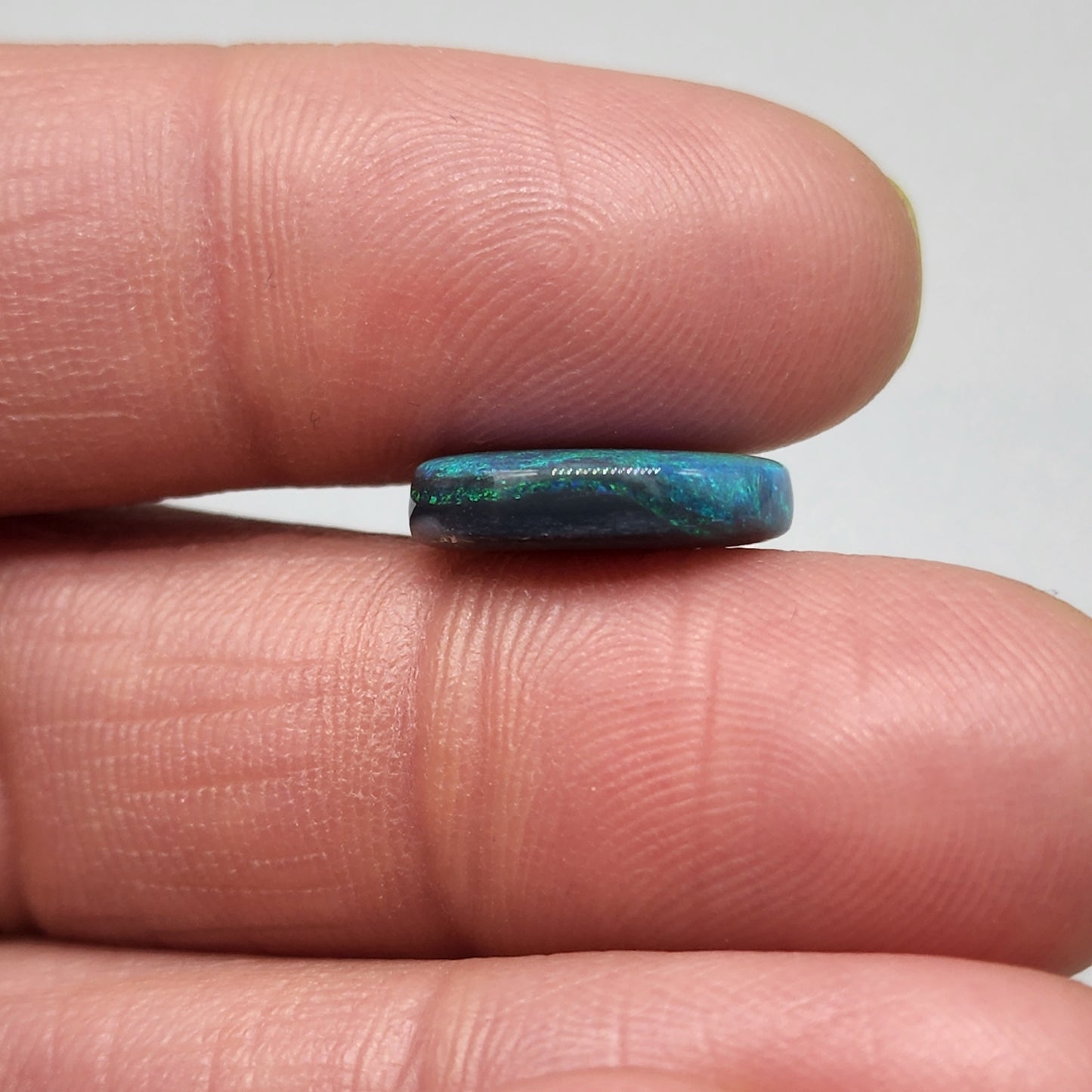 5cts Black Opal with a blue/green color pallet and galaxy pattern.