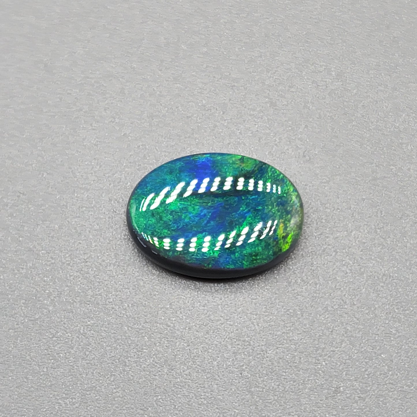 4cts Black Opal with a very Earth like color pallet, small soft patterns with vivid saturation