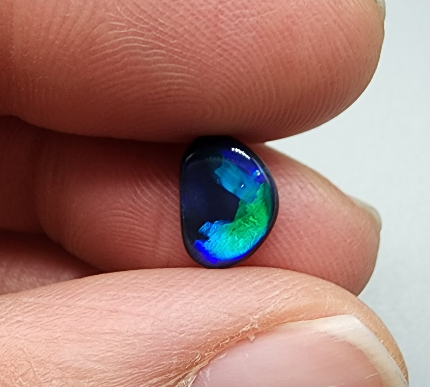 0.95cts Black Opal with rich brush strokes of blue color play fading into a dark center