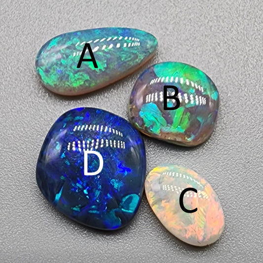 Assorted freeform Dark opal and Black Opals, all have excellent patterning and full faced color.