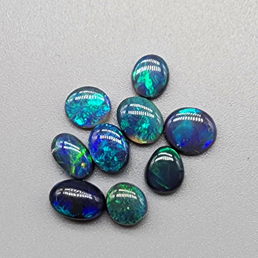 An assortment of accessible black opals with an attractive array of blues, greens and teals